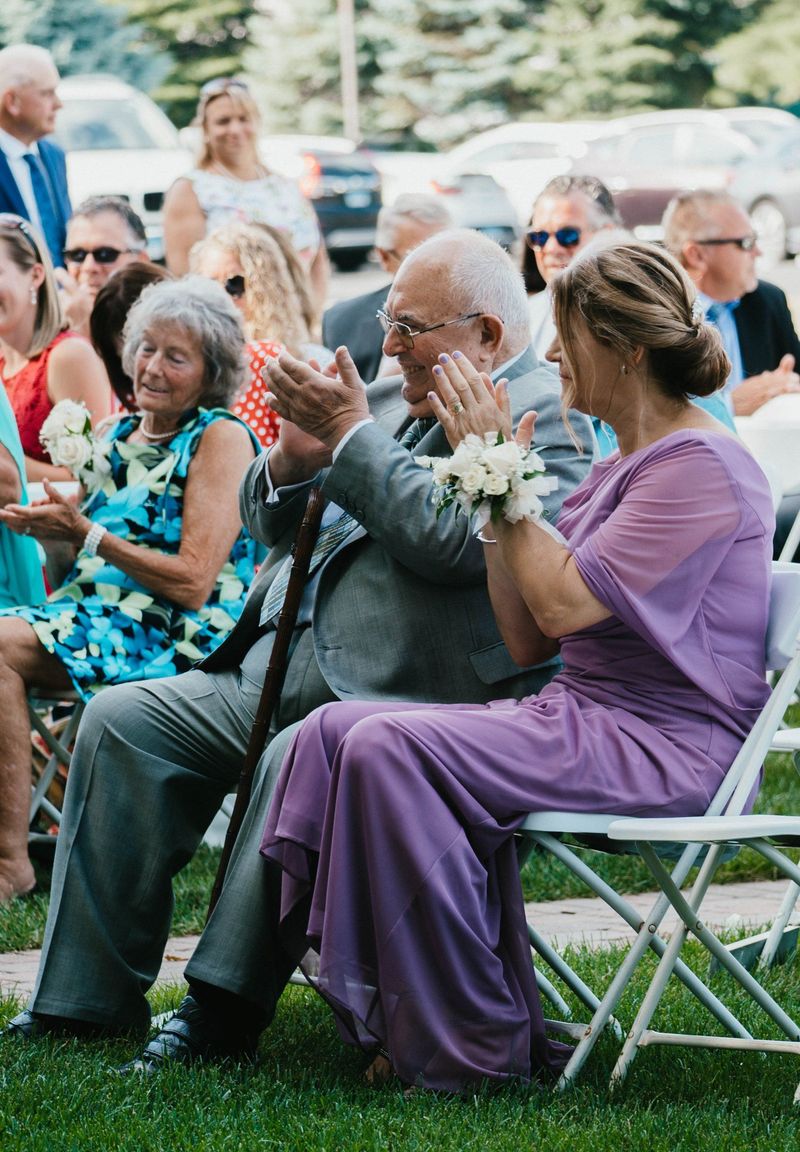 Wedding guests smiling and applauding outdoors