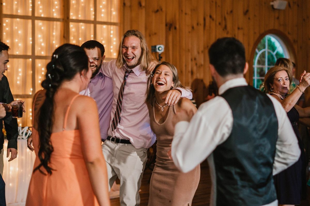 Wedding guests laughing and dancing at the reception