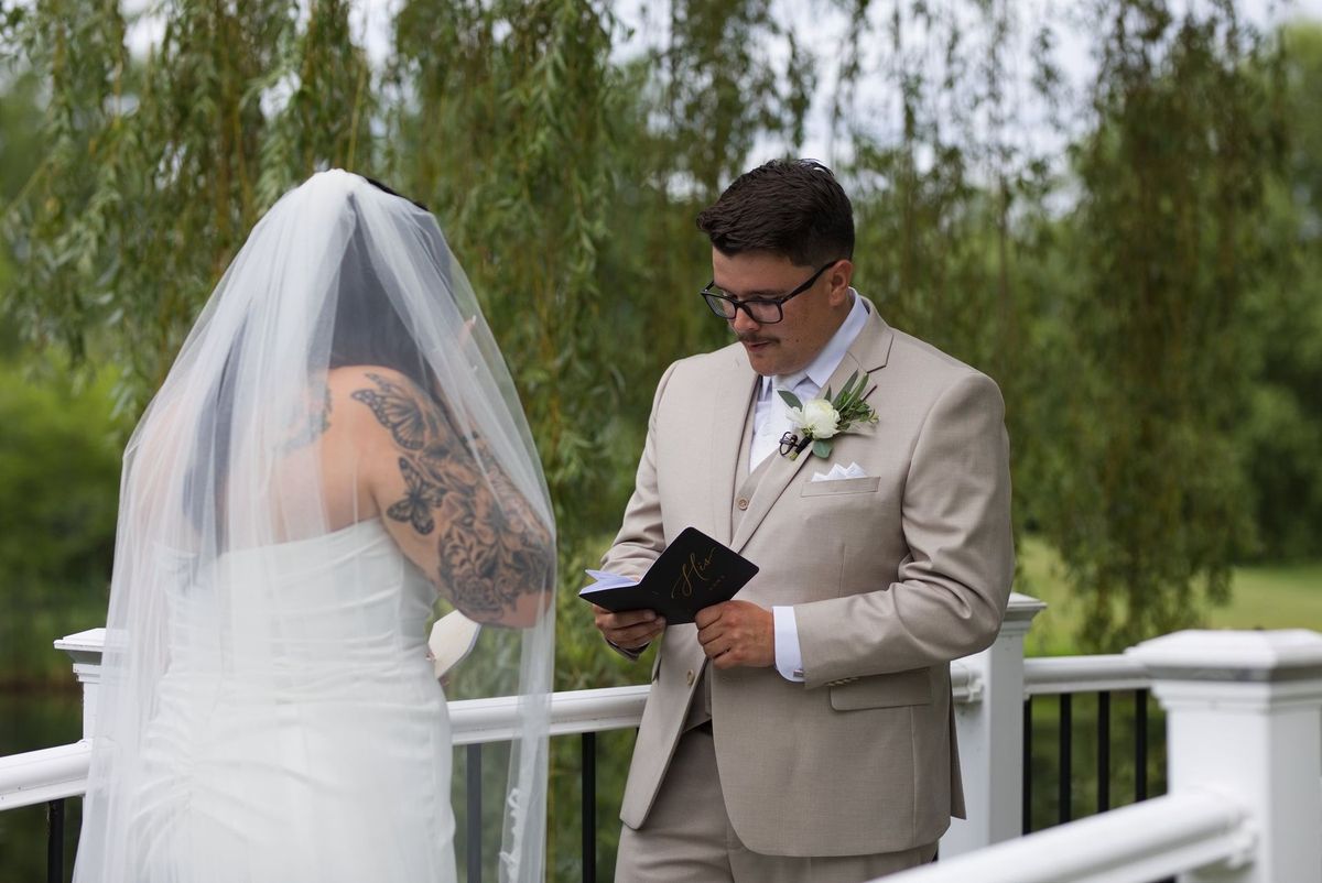 Mat reads from a vow book with Sadie on the bridge