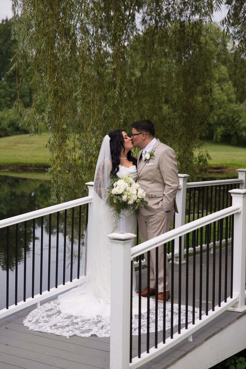 Sadie and Mat kiss beside the bridge railing