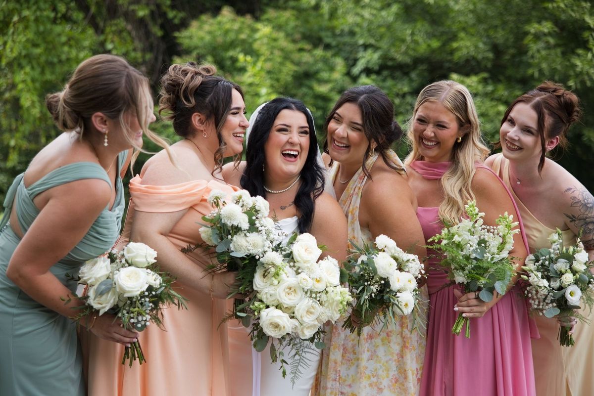 Sadie laughs with her wedding party and their bouquets