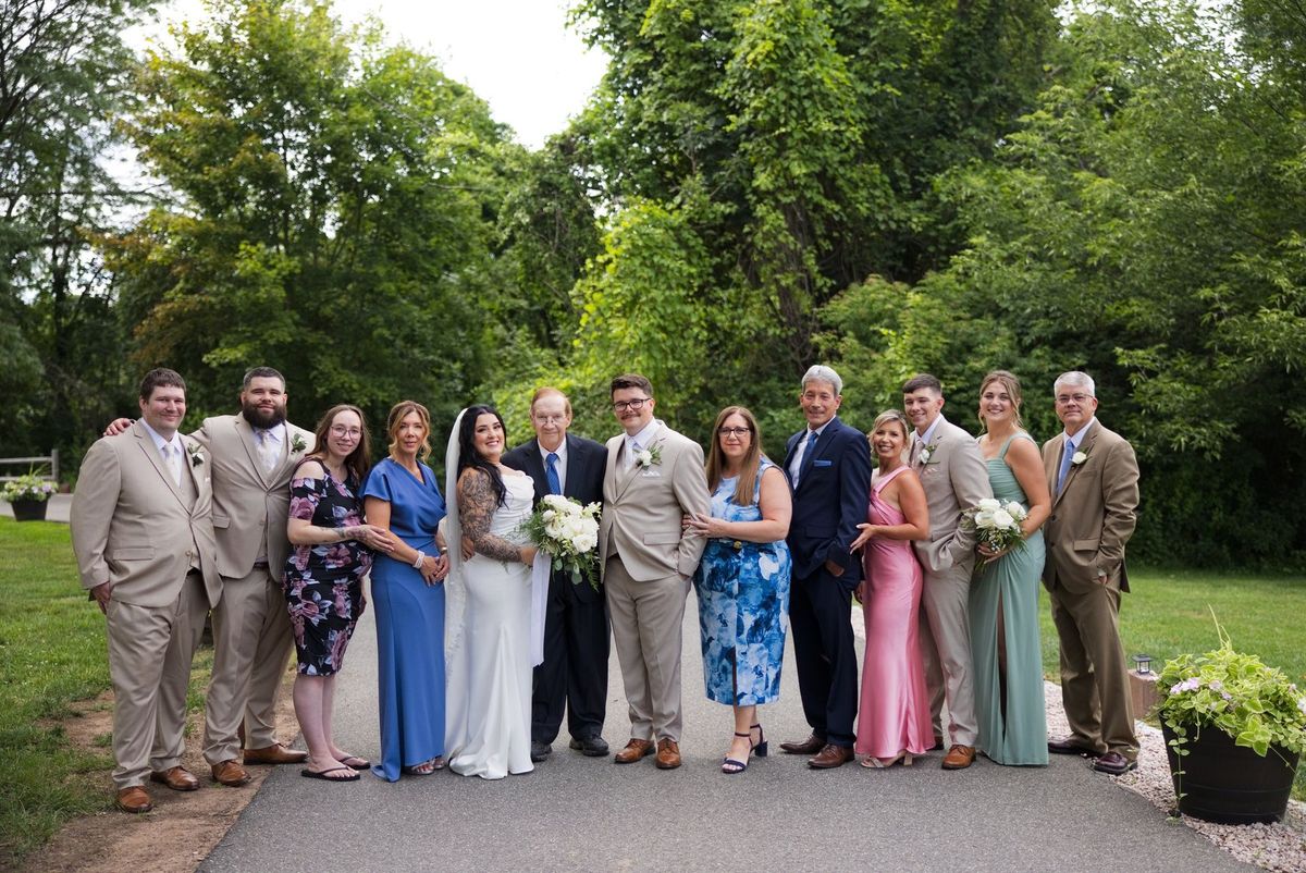 Sadie and Mat pose with a large family group outdoors