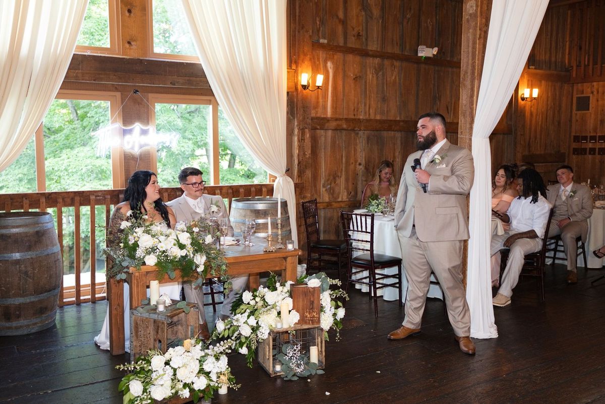 A speaker gives a wedding toast beside Sadie and Mat’s table
