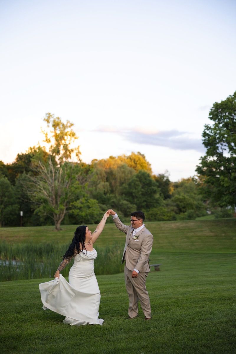 Sadie turns beneath Mat’s raised hand with the evening sky behind them