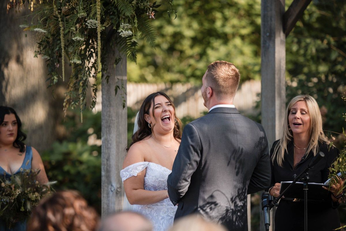 Sophia laughs while facing Tommy during their garden ceremony