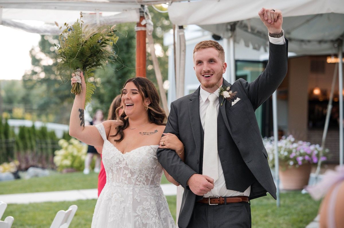 Sophia and Tommy enter their reception smiling and raising their hands