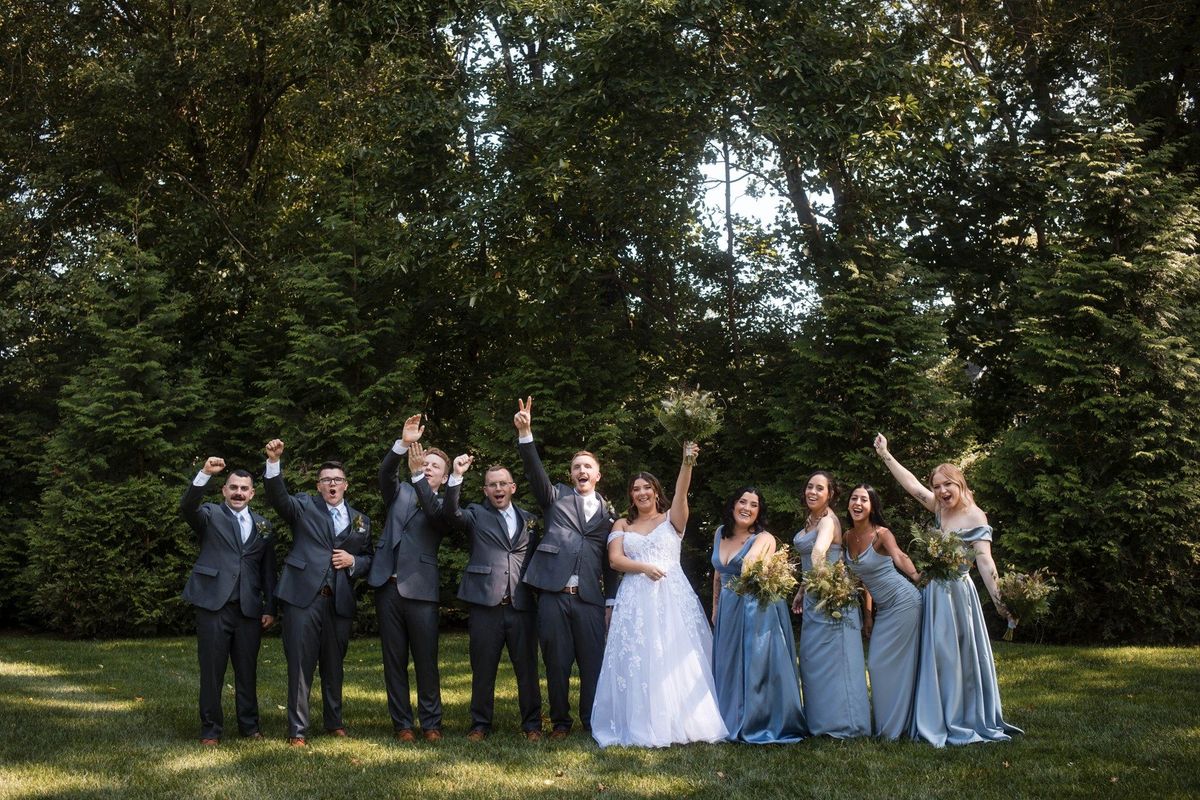 Sophia and Tommy celebrate with their wedding party on the garden lawn