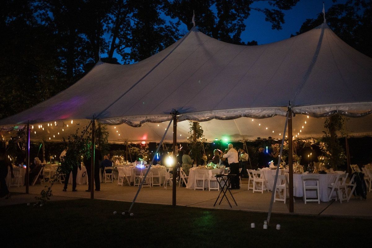The reception tent glows beneath a deep blue evening sky