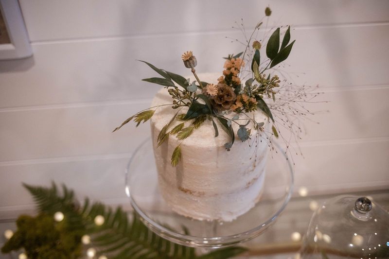 Flowers decorate the small white wedding cake before it is cut