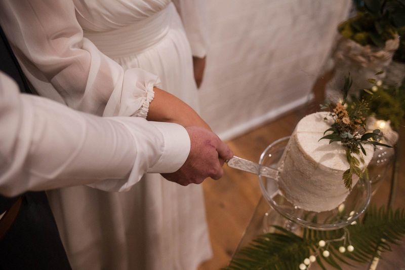 Sophia’s hands guide the knife into the decorated wedding cake