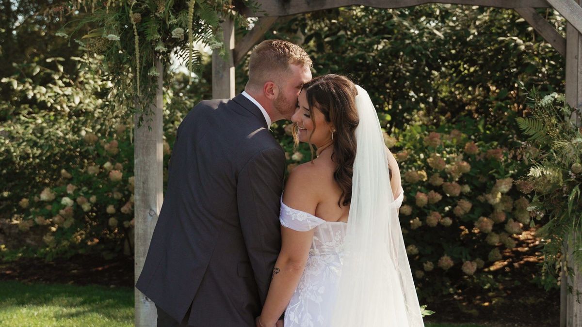 Sophia and Tommy share a kiss in a garden portrait sequence