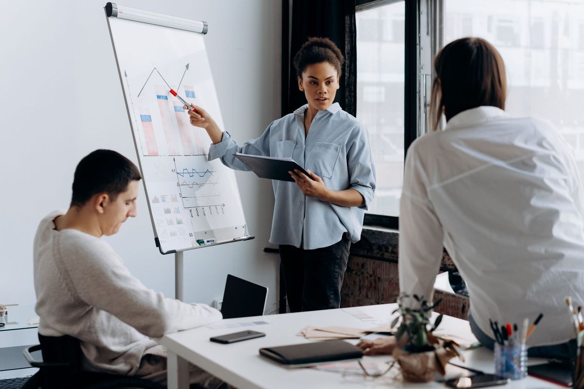 A woman presents to colleagues in a business meeting