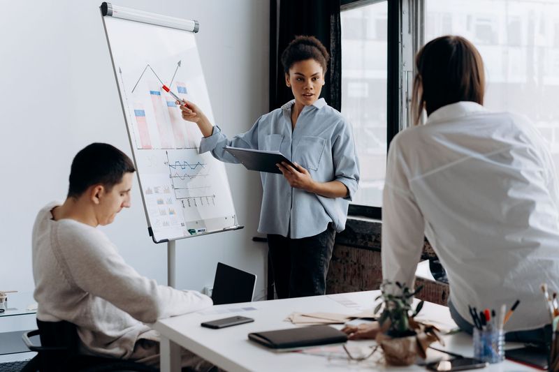 A woman presents to colleagues in a business meeting