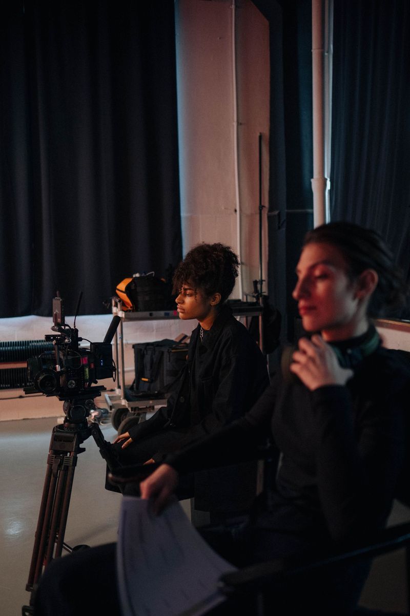 A person in black holding a professional video camera