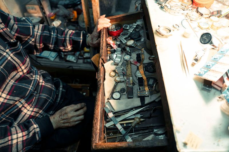 An elderly man working at a bench in a workshop