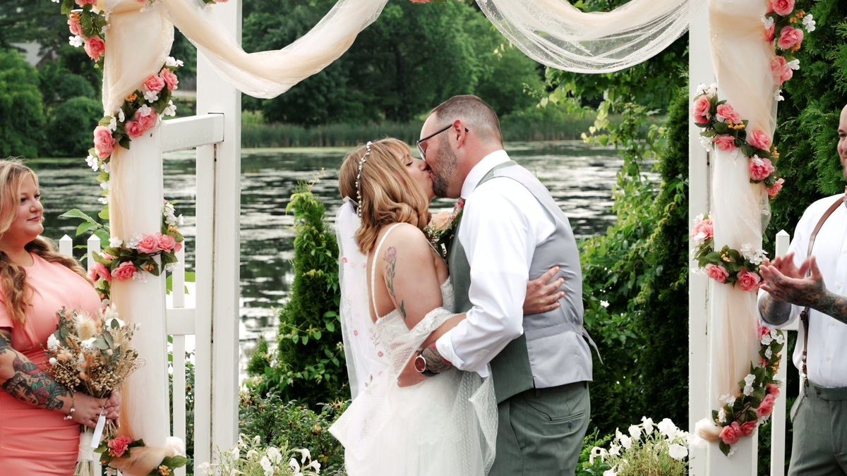 Tyler and Sara share a kiss beneath the ceremony pergola