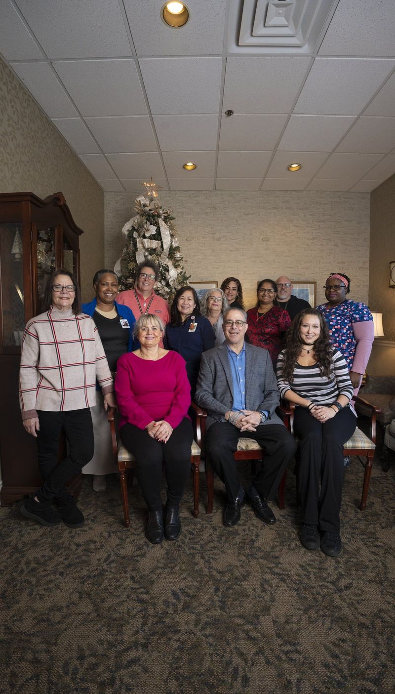 Team group portrait inside a warmly furnished room