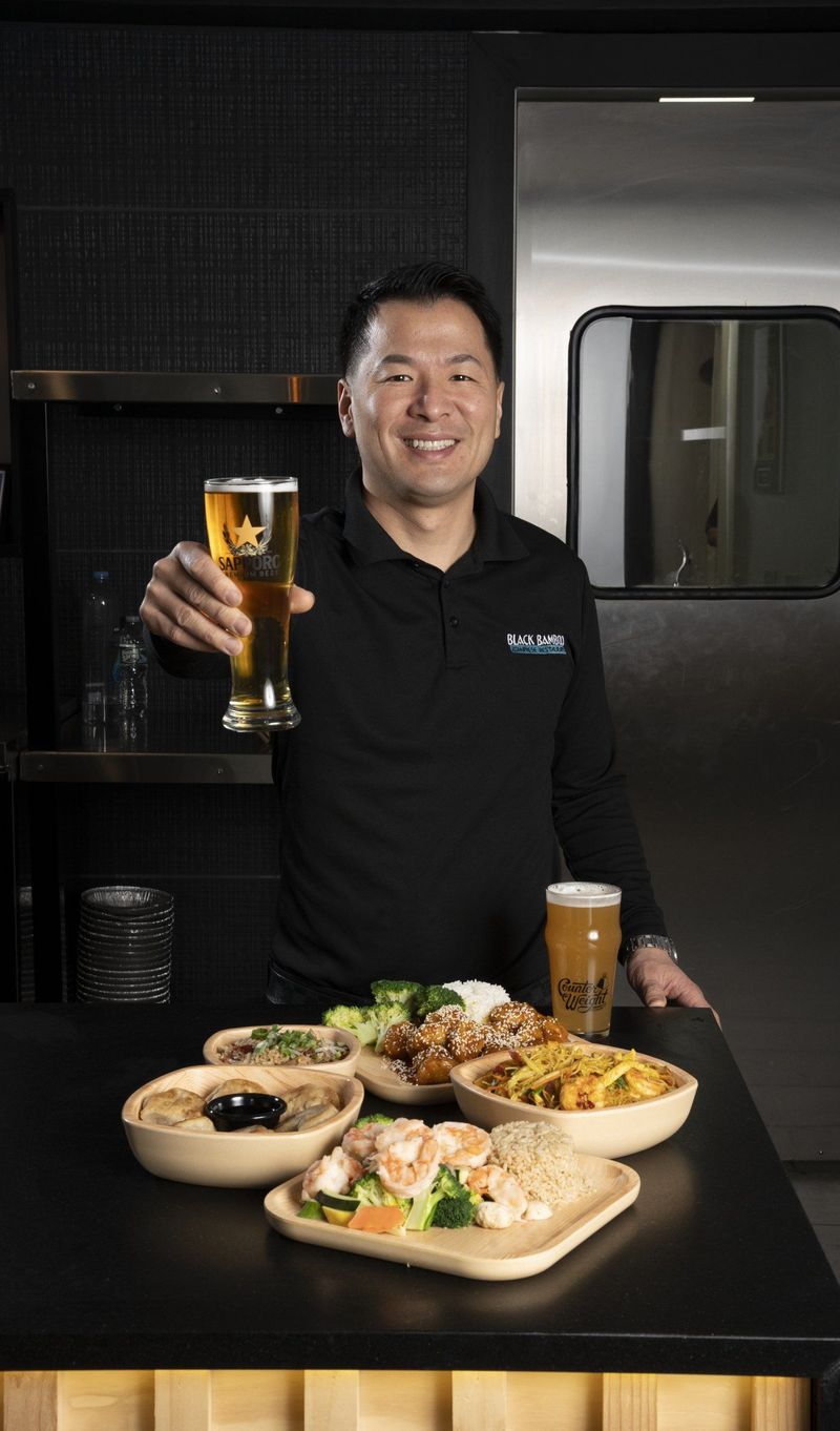 Man raising a glass behind a table of plated food