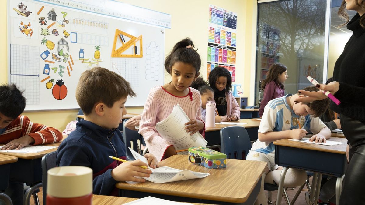 Students working together with small colorful learning pieces at a desk