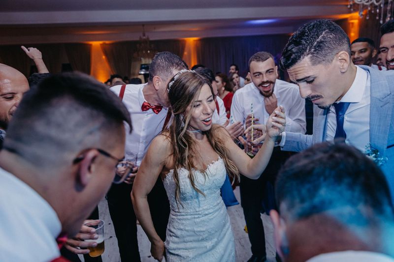 A bride, groom and wedding guests dancing together at a reception