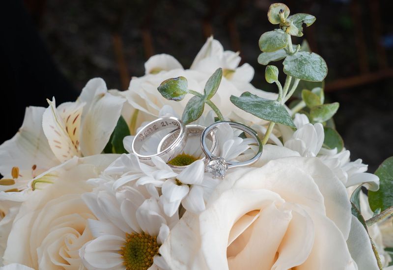 Wedding rings resting on a floral bouquet
