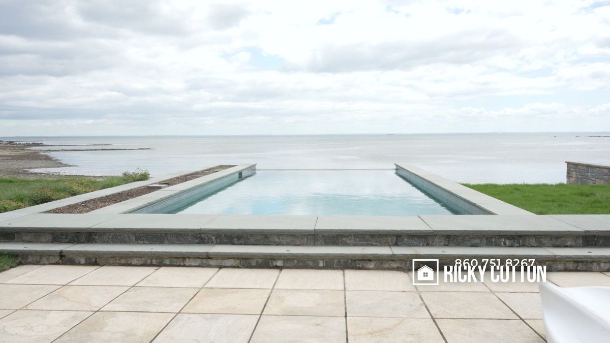 A swimming pool leads the eye toward the waterfront