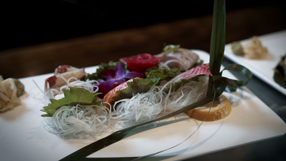 A sashimi presentation arranged in a decorative serving boat