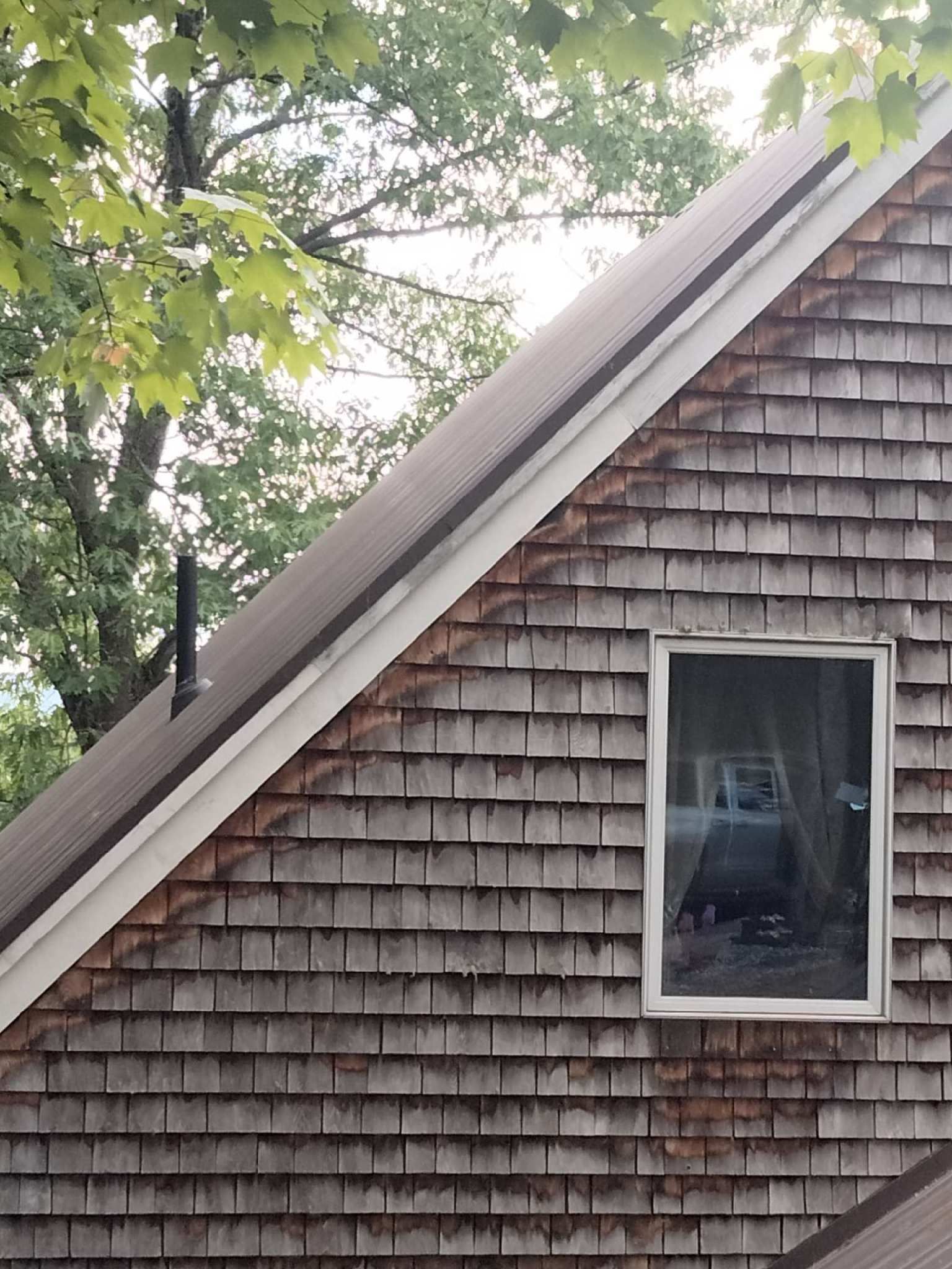 A house with a roof that has a window on it