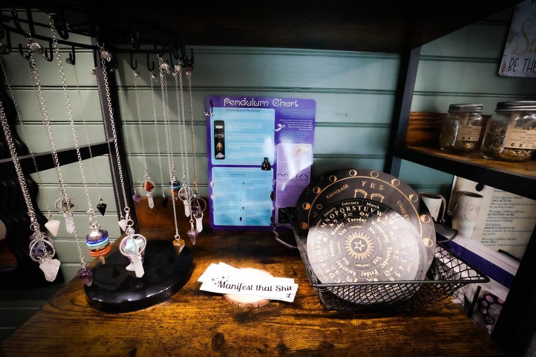A table display of necklaces, a sign, and a decorative plate in a shop.