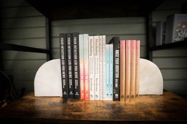A row of colorful yoga mats sitting on top of a wooden shelf.