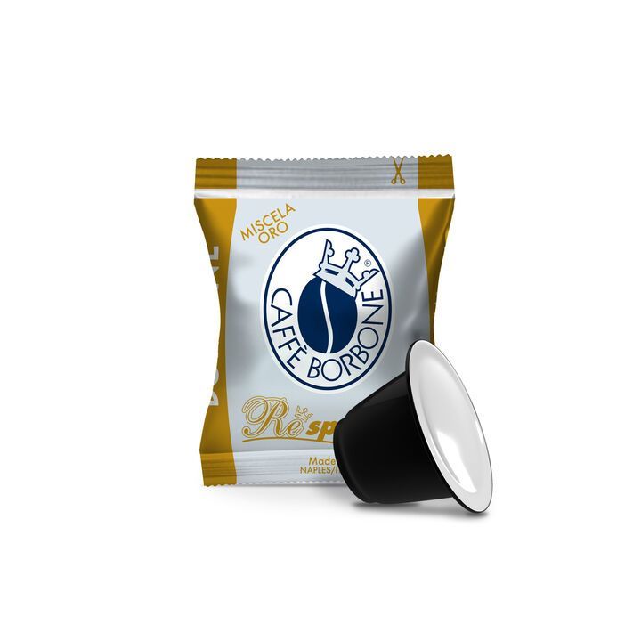 Capsula di caffè accanto a una confezione di cialde di caffè Borbone color oro e bianco.