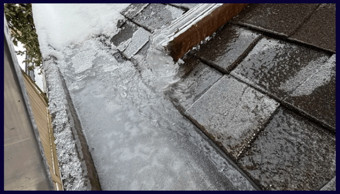 frozen gutter filled with ice from freeze–thaw cycle on a roof