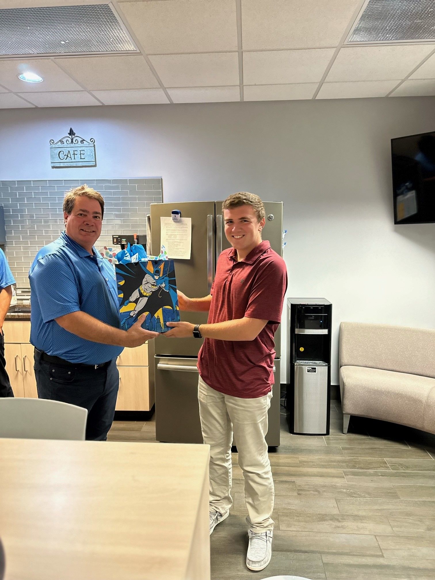 Cody receiving a gift bag from Tim Seifert.