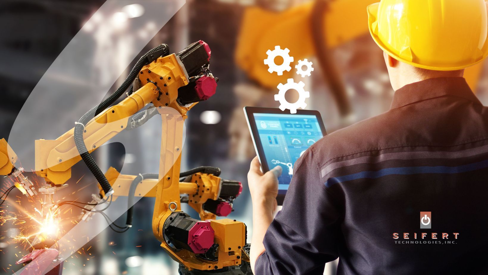 A man in a hard hat viewing a control panel on a tablet, a robotic arm is welding nearby.