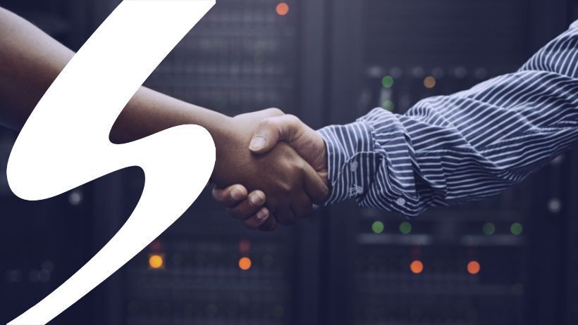 People shaking hands in front of a server room representing a Managed Service Provider.