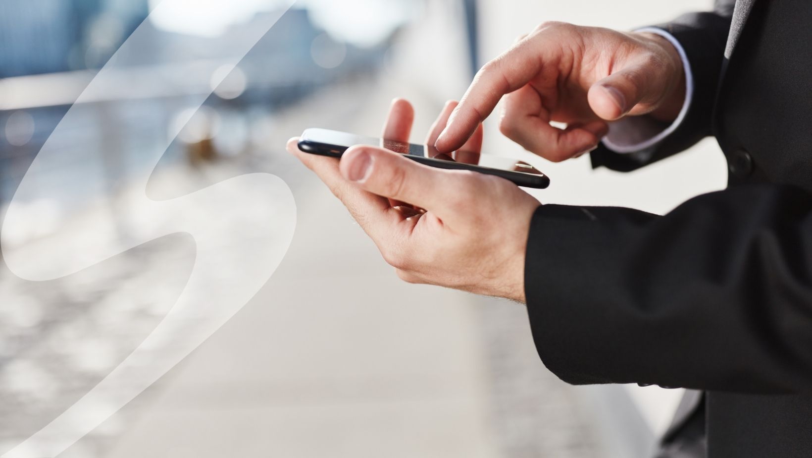 Man in a suit tapping on a phone