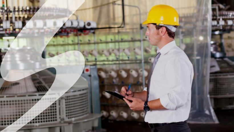 Man in hardhat with pen and clipboard monitoring machinery. Seifert watermark on left