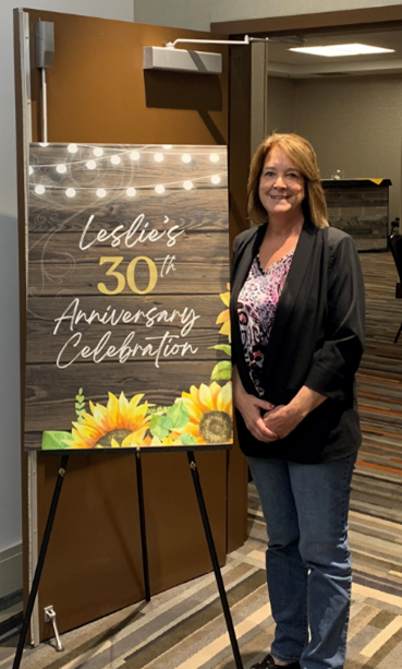 Leslie Callahan, next to a sign that reads