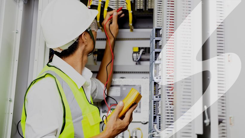 Person working on an electrical system with an electrical tool.