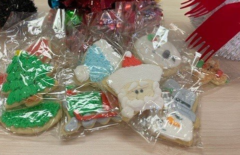 A pile of individually wrapped Christmas-themed sugar cookies.