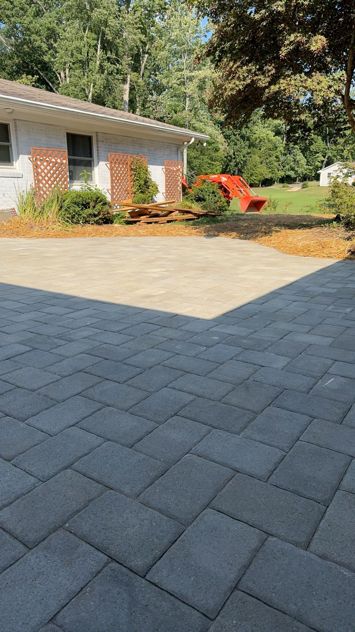 Stone garden path bordered by rocks, mulch, and green plants in a landscaped yard