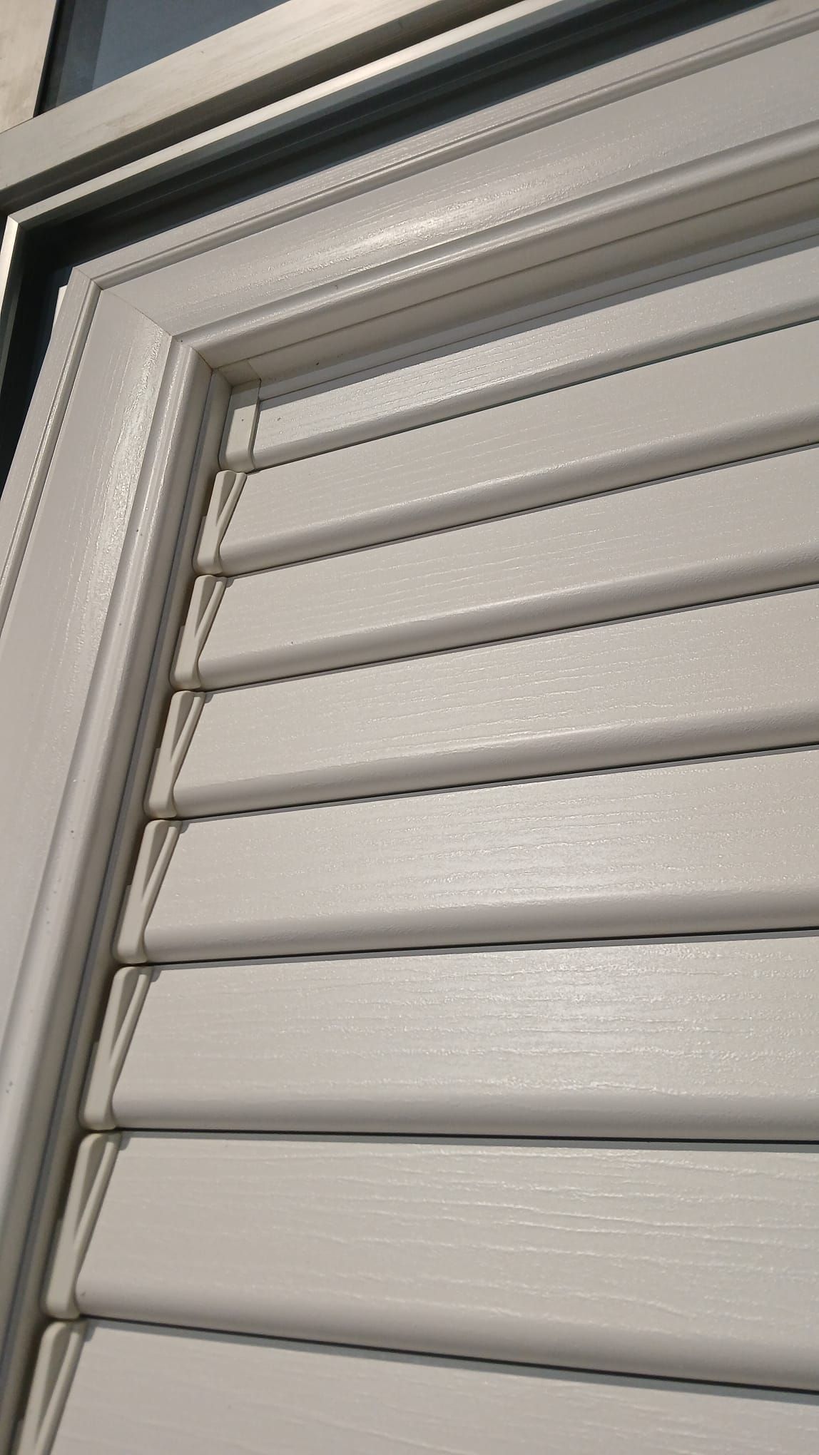 Primo piano di tende a rullo bianche con cornice grigia.