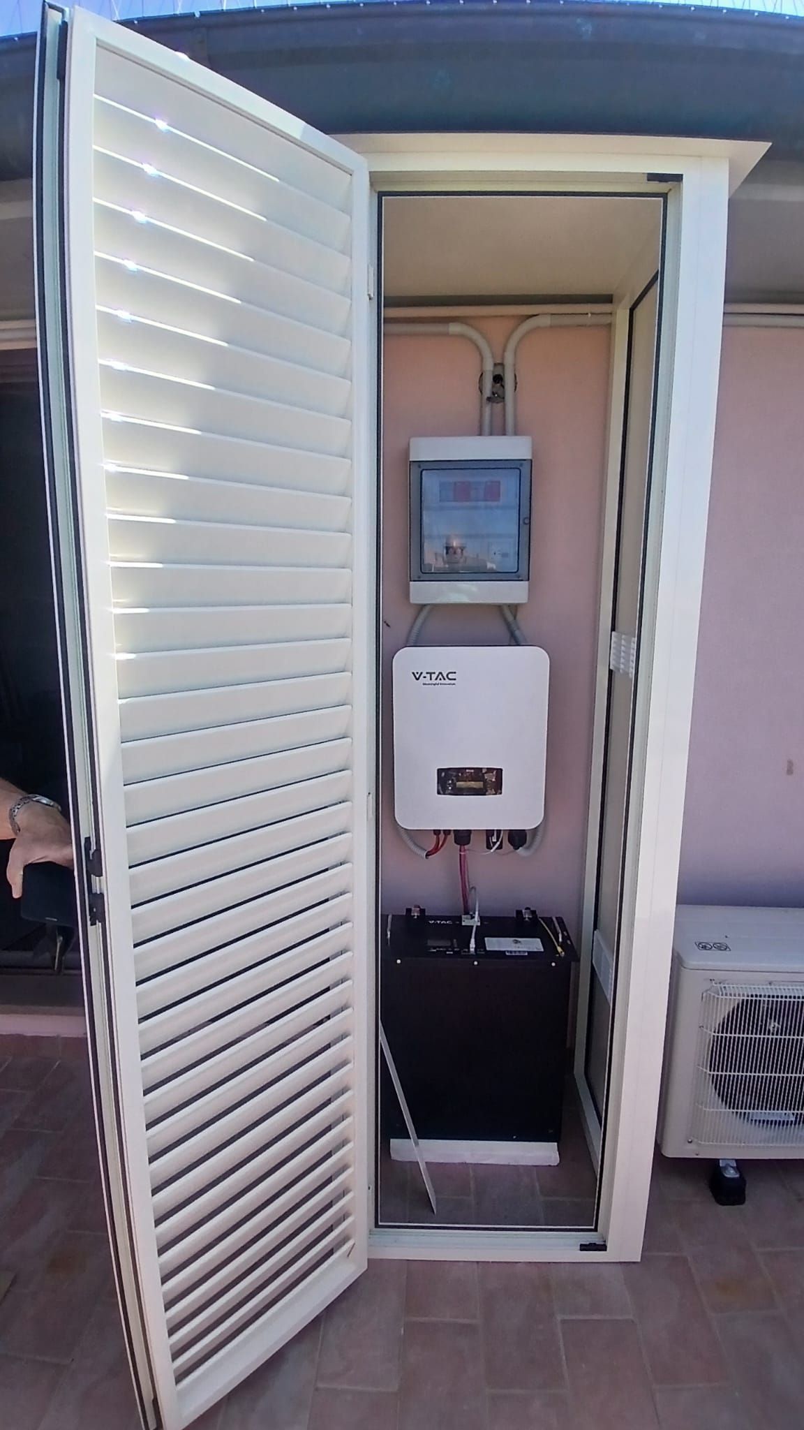 Armadio elettrico di controllo aperto con sportello bianco incernierato e contatori e cablaggi a vista all'interno.