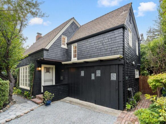 A black house with a garage and a driveway