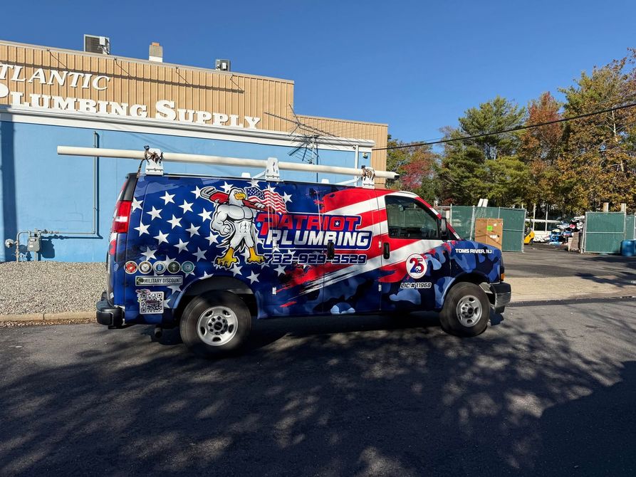 Branded van with American flag wrap parked outside a storefront on a sunny day