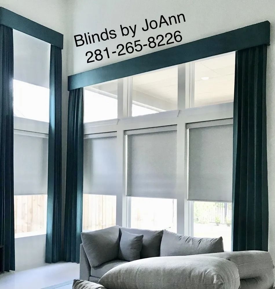 Large windows with teal curtains and roller shades, over a gray couch. Text 