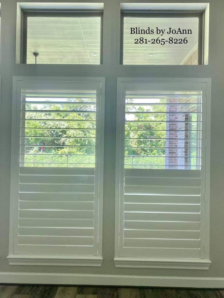 White plantation shutters on two windows with upper fixed glass panels.