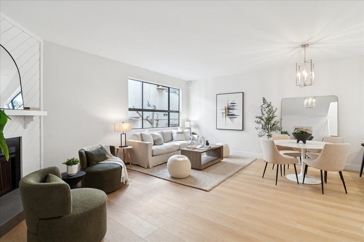 Bright modern living and dining room with neutral furniture, large windows, light wood floors, and a dining table.