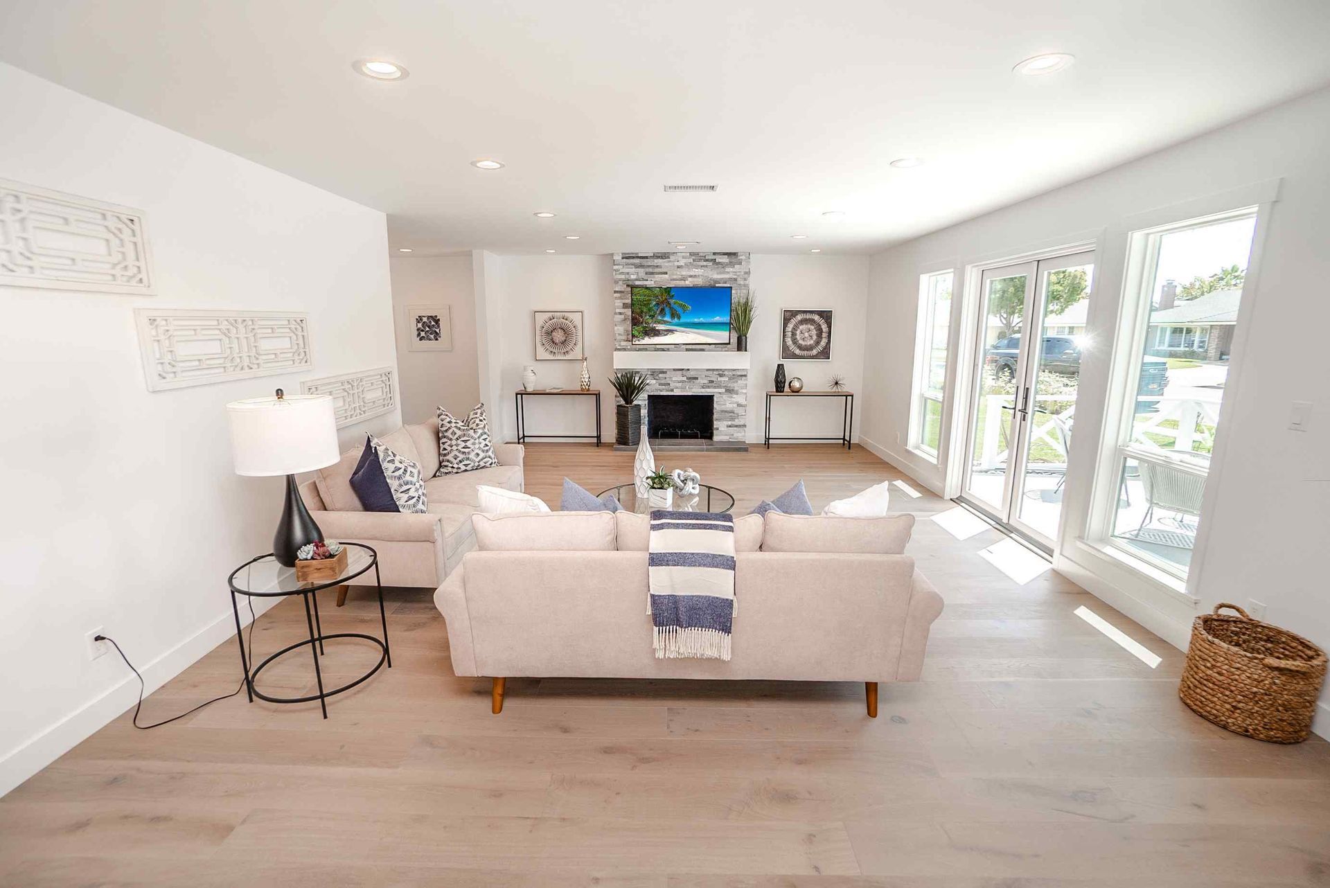 Bright living room with light wood floors, white walls, and modern furniture.