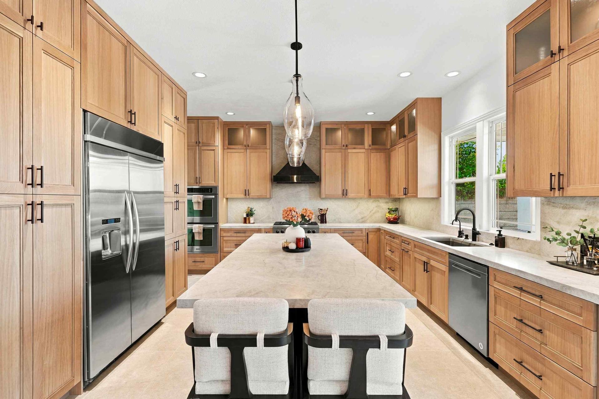 Modern kitchen with wood cabinets, stainless steel appliances, and a central island with stools